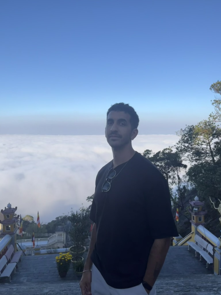 Francisco on a temple staircase above a sea of clouds